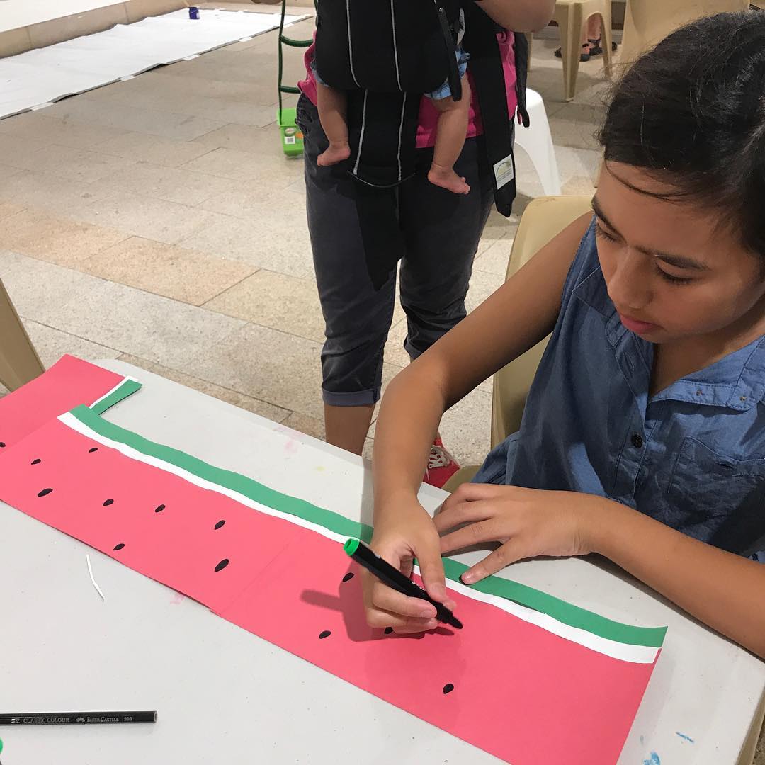 Little artists at the Chatswood Family Festival at The Concourse making their own watermelon paper fans to keep cool!